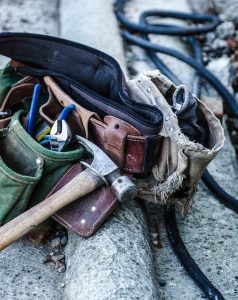 A commercial general contractor’s tool belt, laying on the ground.